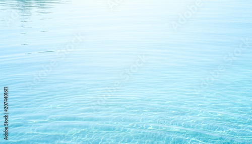 Calm clear light blue water surface with gentle ripples texture 穏やかなライトブルーの水面に広がる細やかな波紋のテクスチャ背景