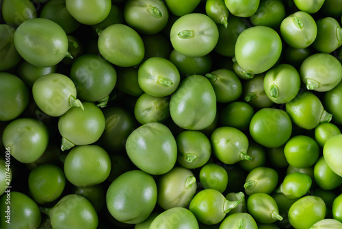 Close-up view of fresh green peas filling the frame, showing smooth round vegetable texture and natural green color.
