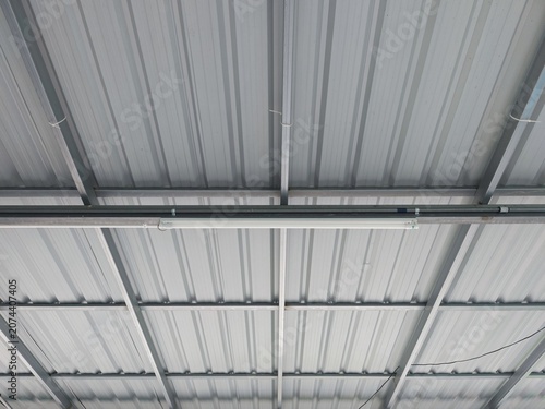 Quadro su tela Corrugated metal sheet roof structure with steel beams in industrial building