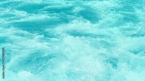 super slow motion of real wild water texture, close-up and high angle view of splashing flowing water with white foam in sunshine