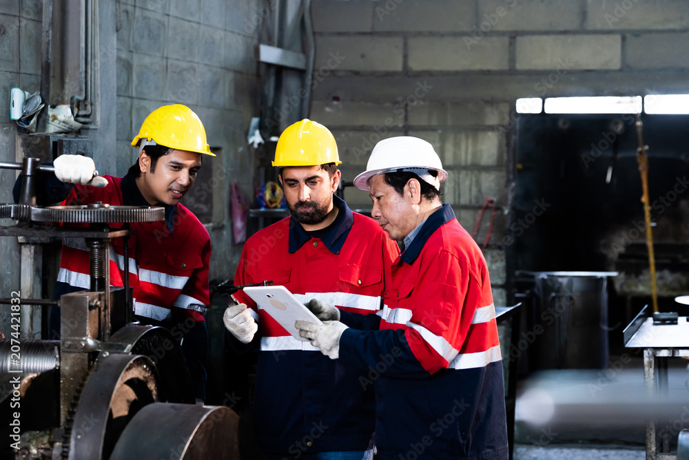 Fototapeta premium Teamwork in industry with professional mechanics checking product quality using caliper.