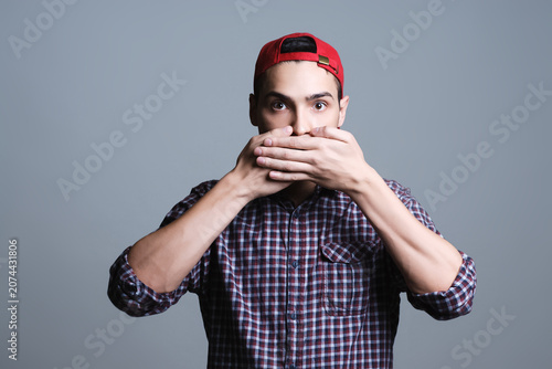 Fotografía Young man covering mouth feeling surprised and speechless
