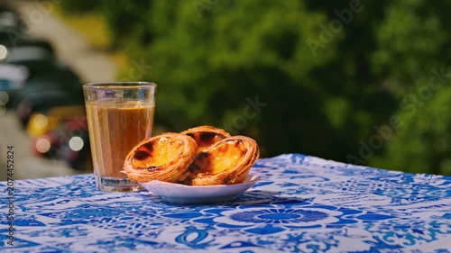 Static shot of pastel de nata dessert and glass of meia de leite