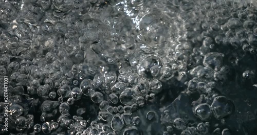Bubbling water with air bubbles. Cavitation of water flow. Water texture.