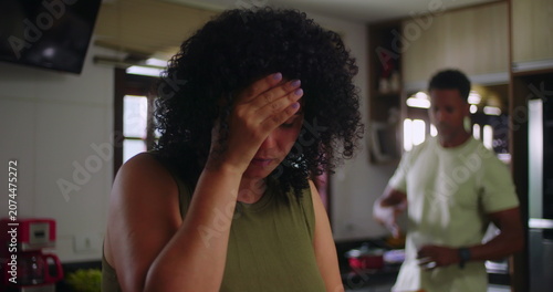 Photos Wife holding head in frustration during argument in kitchen, emotional tension a