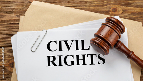 Wooden Judge Gavel on Civil Rights Legal Document with Paper Clip on Rustic Wood Table