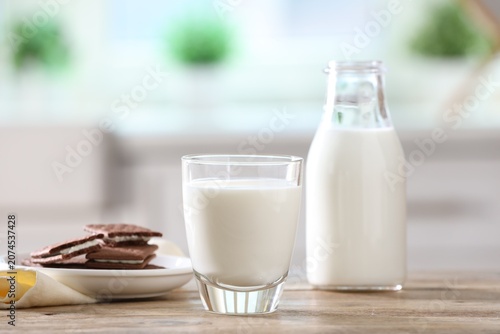Photography Fresh milk and chocolate sandwich cookies on wooden table in kitchen