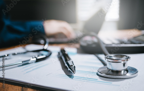 Medical data analysis concept. Stethoscope and pen on health report for clinical research, healthcare planning, patient record, and professional diagnosis.
