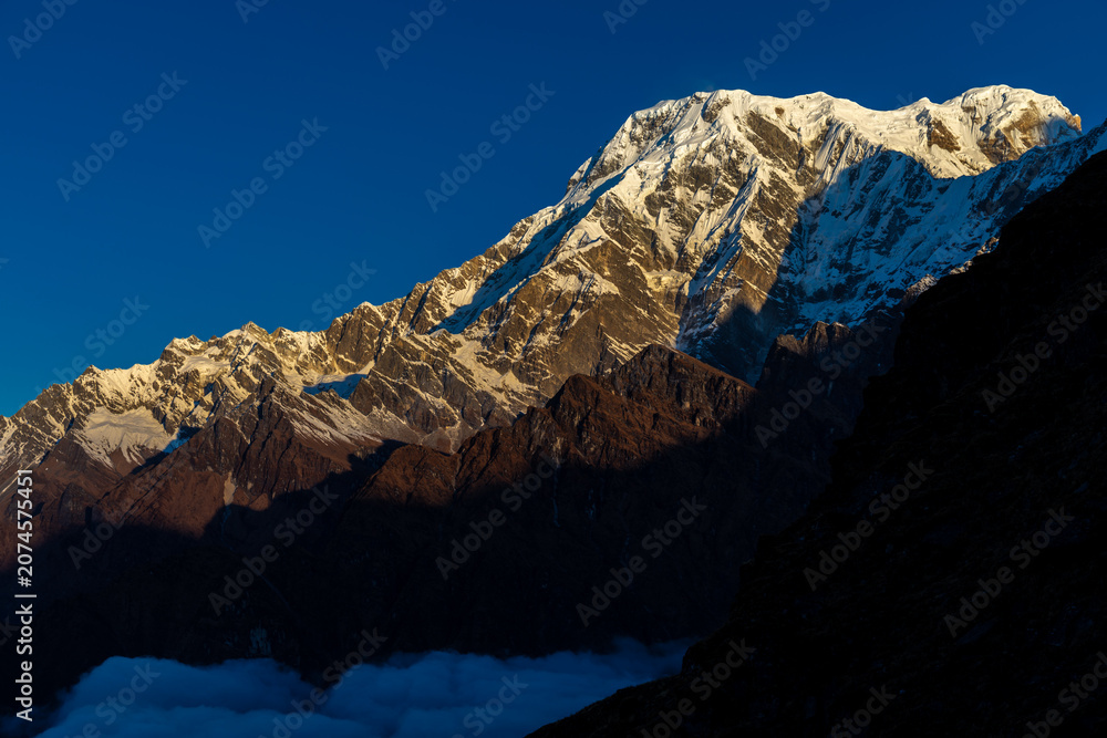 Fototapeta premium Spectacular view of the Annapurna mountain range seen from the Annapurna Base Camp trekking route in the Himalayas of Nepal. Towering snow-covered peaks rise dramatically above the surrounding glacier