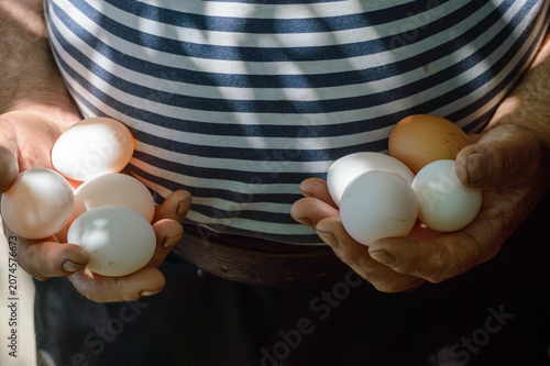man holding a chicken eggs in his hand