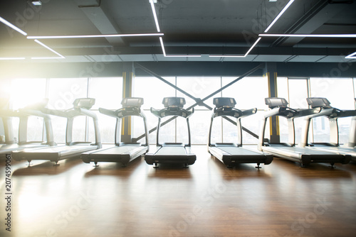 Bild auf Leinwand Gimnasio bien iluminado con una gran variedad de equipos para hacer ejercicio