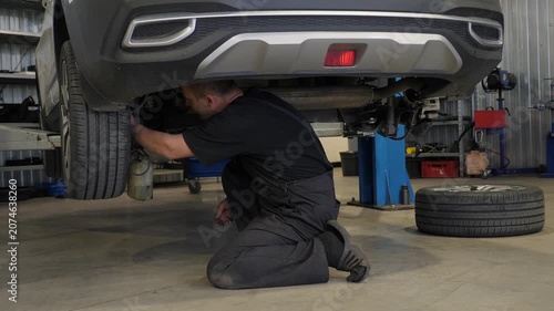 The mechanic repaired the car at the service station. He drained the brake fluid and checked under the car, which was on the lift.