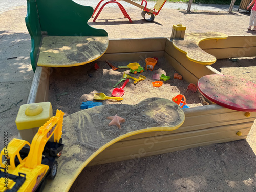 Obraz na plátně Empty sandpit in a playground with colorful toys