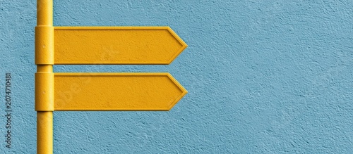 Yellow directional arrows on a blue textured wall