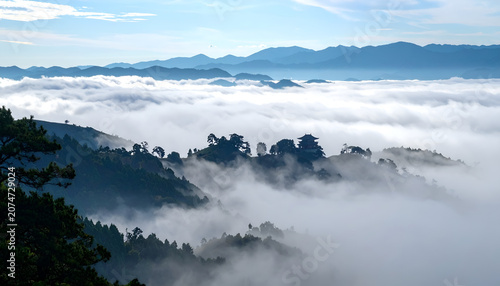 Misty Mountain Landscape with Fog Rolling Over Hills at Sunrise.