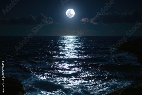 Full moon illuminates a dark, choppy sea with rocky shorelines