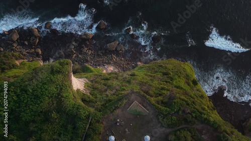 aerial view of dark sunset tide crashing on a rocky shore. Peaceful and dramatic nature background for ambient, relaxation, or titles