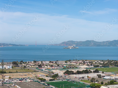 Aerial view presenting Treasure Island's residential and commercial areas, stretching across the bay towards Alcatraz Island and the distant Golden Gate Bridge