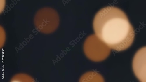 Golden light orbs glowing against a dark background, abstract motion graphic animation, seamless loop, soft focus light particles floating in the night