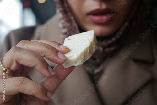 Obraz na plátne Woman holding a piece of cheese in a cafe