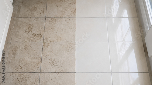 A tiled floor showing a clear contrast between dirty, muddy tiles on the left and clean, shiny tiles on the right under natural light.