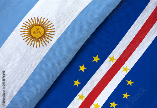 Fotografie High-angle macro shot of the textile national flags of Argentina and Cape Verde overlapping to symbolize sports rivalry or diplomacy