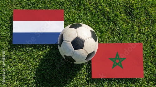 Netherlands And Morocco National Flags With Soccer Ball On Green Grass Field Top View