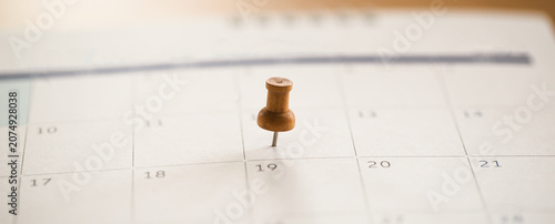 Close up view of calendar with colorful pins on dates.