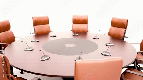 Rotating view of an empty corporate conference round table setup with microphones. Isolated business meeting room furniture on white background for presentation and teamwork concepts