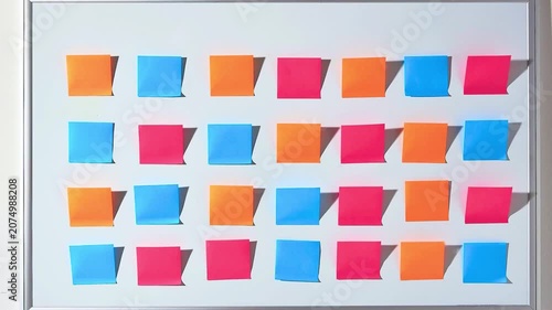 Stop motion animation of colorful sticky notes changing colors on a white board. Ideal background for agile project management, brainstorming, and creative office concepts