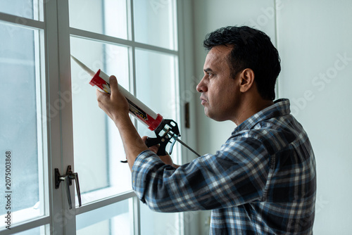 Photography Man sealing window frame photo