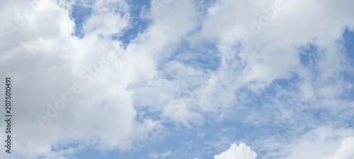 Tableau sur toile fluffy white clouds building up in the light blue sky