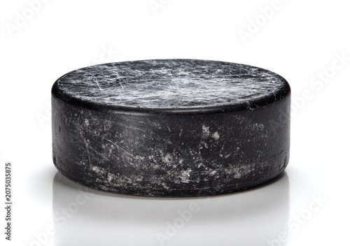 Close-up of a dark, textured hockey puck on a white background.
