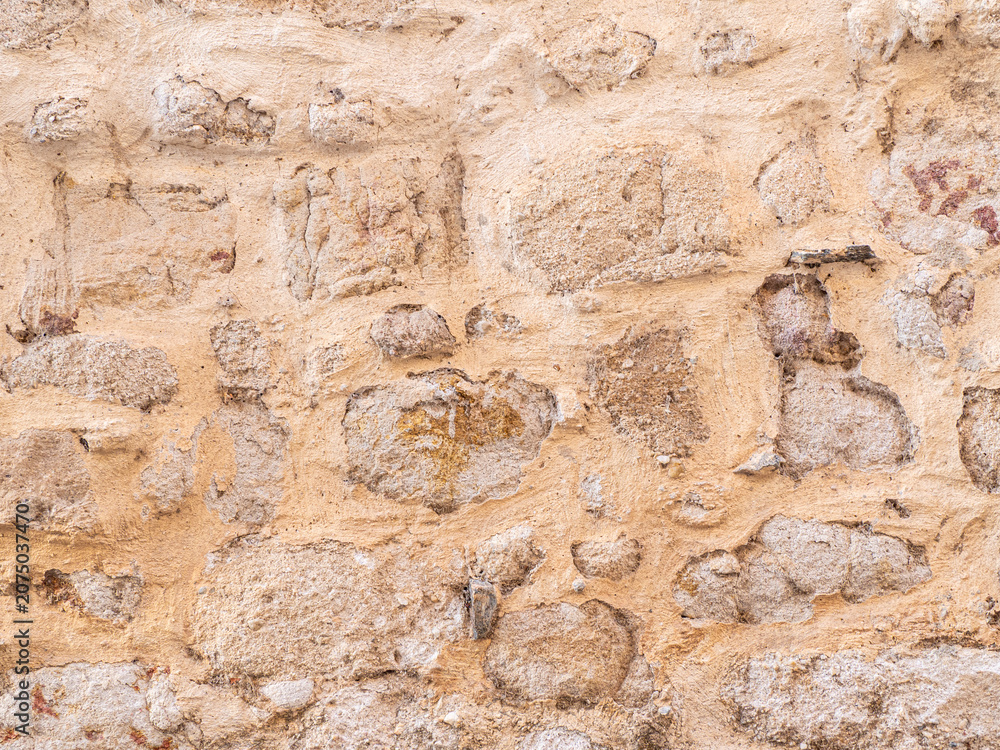 Naklejka premium Ancient stone wall showing eroded rustic texture