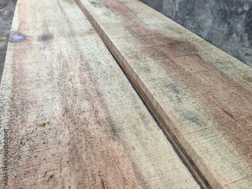 Close up of rough sawn timber planks and wooden boards at construction site, raw unpolished wood material with natural texture grains and cutting lines for carpentry industry