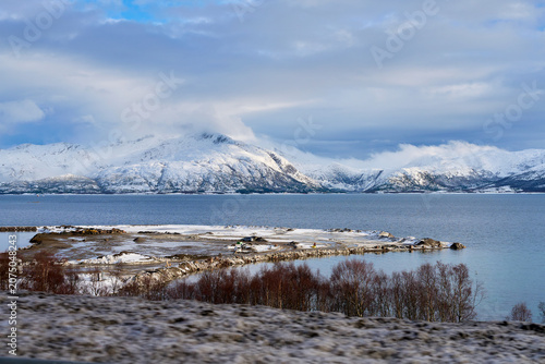 Stunning Winter Panorama of Lofoten Norway Snow Capped Mountains and Coastal Peninsula with Deep Blue Fjord Water Scenic Arctic Landscape and Wilderness Travel View