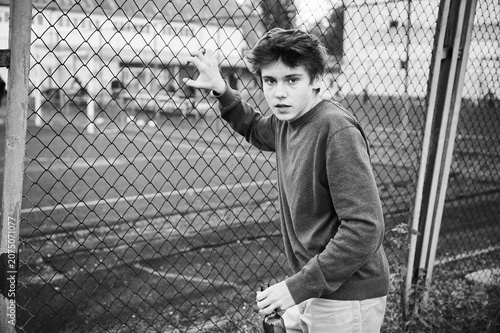 Foto Teen boy remains at fenced sports area with bottle