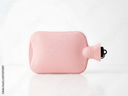 Pink hot water bottle on plain background