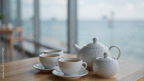 Tea set with cups and teapot on a table by the ocean view