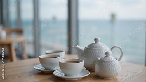 Tea set with cups and teapot on a table by the sea