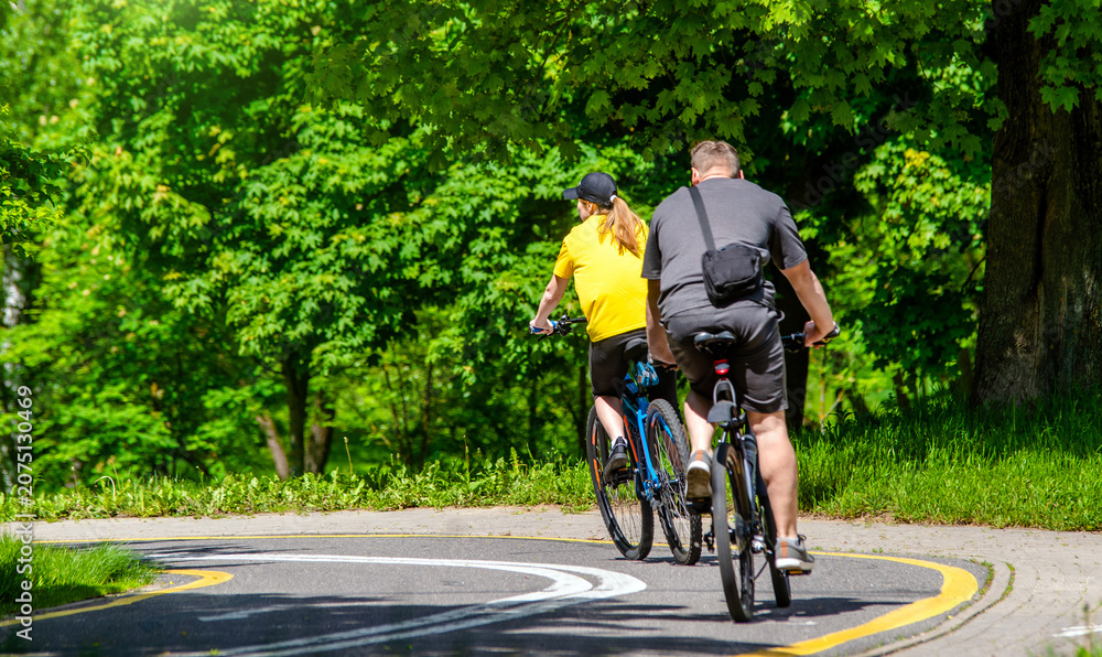 Fototapeta premium Cyclists ride on the bike path in the city Park 