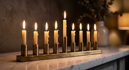Lit hanukkah menorah with white candles on marble surface