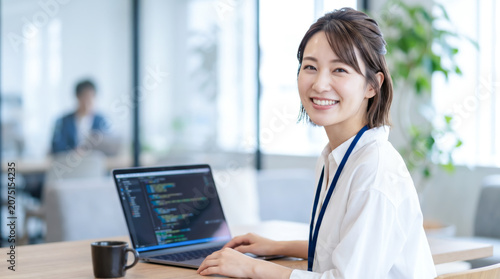 オフィスでパソコンに向かいプログラミングや開発業務をする女性システムエンジニア・SE