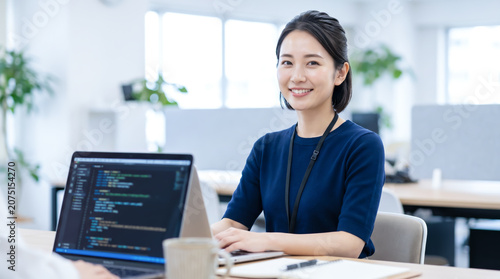 オフィスでパソコンに向かいプログラミングや開発業務をする女性システムエンジニア・SE
