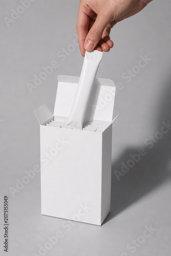 Hand Pulling Blank White Stick Pack Sachet from Paper Box Mockup