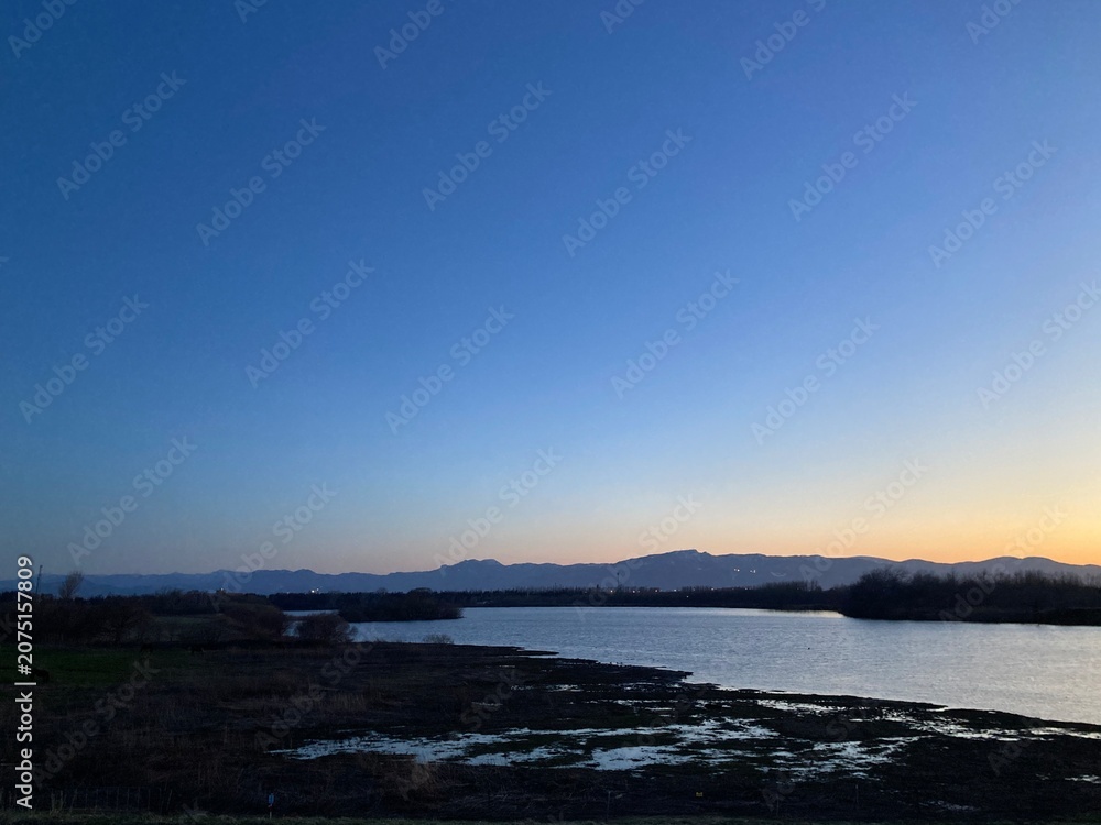 Obraz premium Peaceful Wetland at Twilight with Mountain Silhouettes