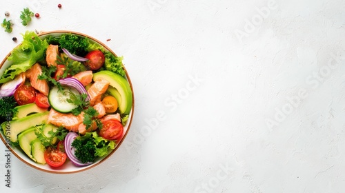 fresh salad bowl with avocado, salmon and vegetables on bright table