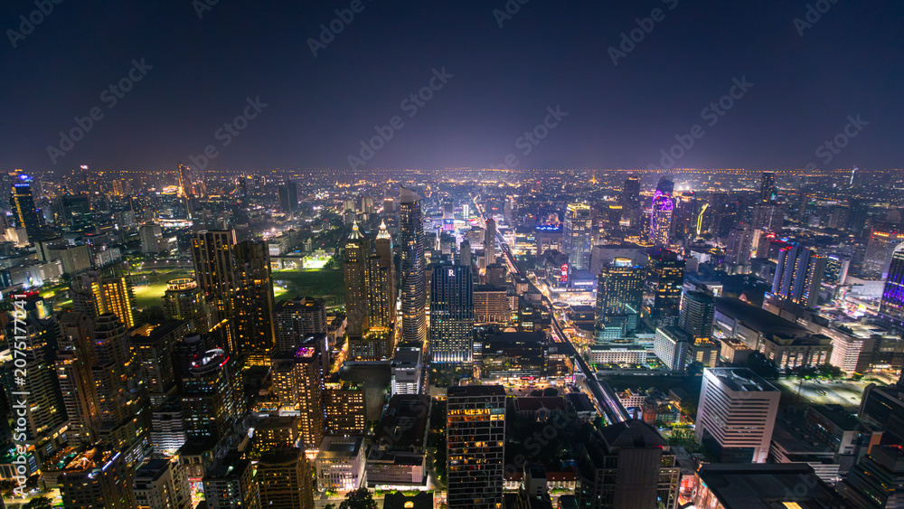 Obraz premium The Bangkok skyline at night, viewed from a rooftop bar in Thailand