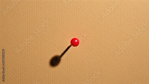 Single push pin on a cork board, symbolizing simplicity and organization in a minimalist setting.