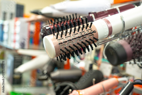 A Colorful Array of Hair Styling Tools Displayed on Shelves in a Beauty Supply Store Featuring Brushes, Curling Irons, and Hair Dryers